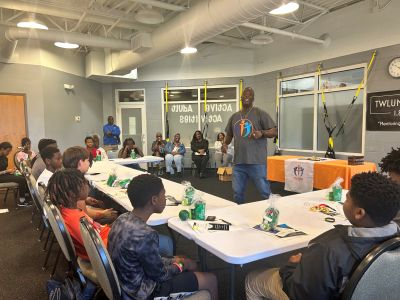 Photo of a man speaking to a group of teens